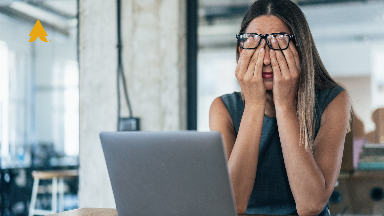 Woman tired or stressed out at her desk- CRM Fatigue: CRM Data Management blog featured image